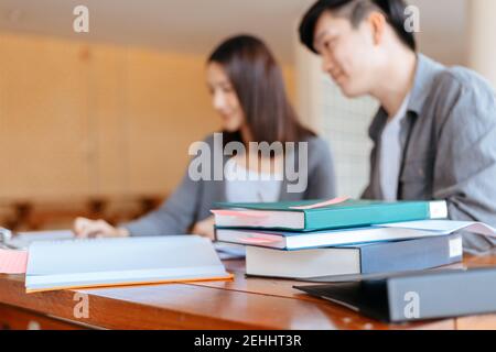 High school or college students  group catching up workbook and learning tutoring on desk and reading, doing homework, lesson practice preparing exam. Stock Photo