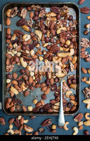 Roasted nuts in a baking tray on a slate background Stock Photo
