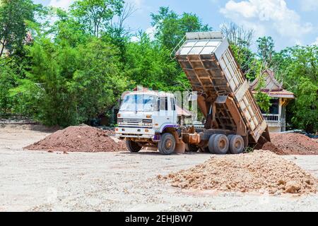 Dump truck is moving down soil on construction site. Stock Photo