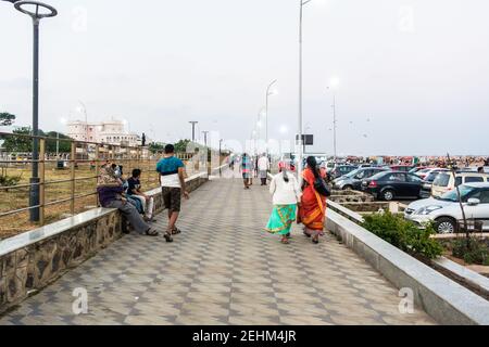 Visitors walking in Chennai Marina beach promenade to enjoy the cool evening sea breeze Stock Photo