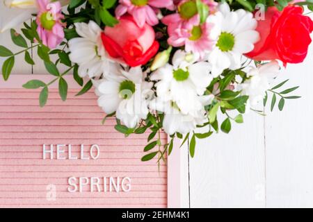 Quote - Hello spring. Border frame made of blooming flowers on a white background. Stock Photo