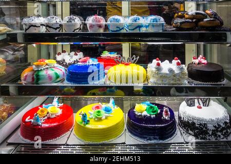 Pasteries and cakes on display in glass door in a bakery in Chennai, Tamil Nadu, India Stock Photo