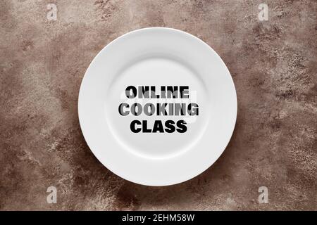The word online cooking class written on a white dish. Online cooking education or training concept. Stock Photo