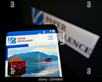 Smartphone with website of Canadian paper and pulp manufacturer Paper Excellence BV on screen in front of logo. Focus on top-center of phone display. Stock Photo