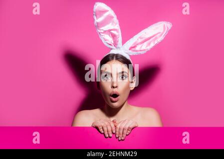 Funny emotions, excited expressing. Bunny woman isolated on pink. Stock Photo