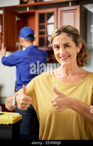 Woman happy with repairmans work Stock Photo