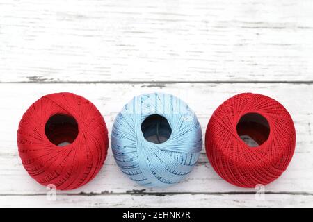 Ball of red and blue threads on white wooden table Stock Photo