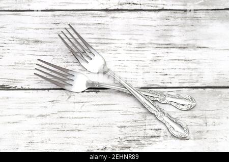 Dining retro silver forks on white grunge wooden table Stock Photo
