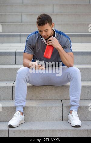 Young man looking at phone portrait format outdoor Stock Photo