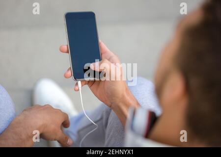 Young man looking at smartphone smart cell phone using cellphone copyspace copy space outdoor Stock Photo
