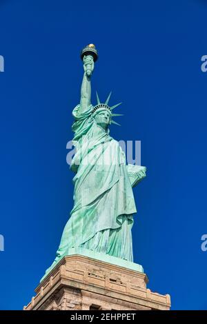 The Statue of Liberty in New York City USA daylight close up low angle view  with blue sky  in background Stock Photo