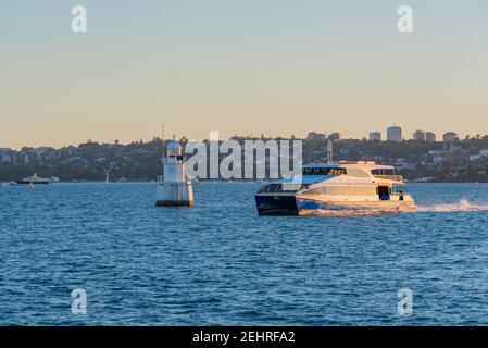 An NRMA Manly Fast Ferry travelling quickly down the harbour from Circular Quay to Manly Wharf on a sunny summer afternoon in Sydney, Australia Stock Photo