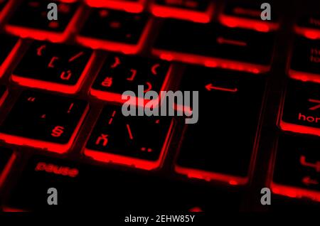 Red iluminated backlit keyboard, on laptop or keyborad computer of gaming in the dark. Cyber Attack, hacking and Internet security concept. Stock Photo