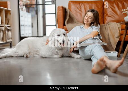Woman working at home sitting with dog Stock Photo