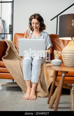 Woman working with laptop and headphones from home Stock Photo