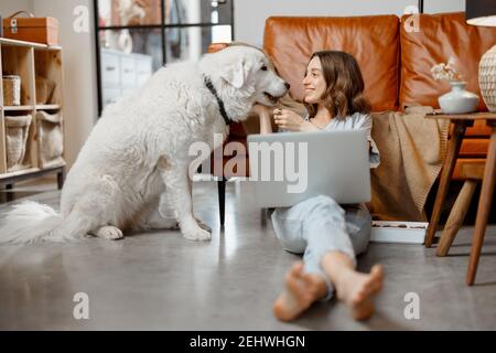 Woman working at home sitting with dog Stock Photo