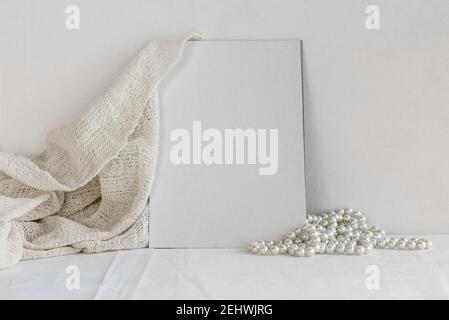 Blank white greeting card and pearl necklace on white background. Romantic background for the invitation. Stock Photo