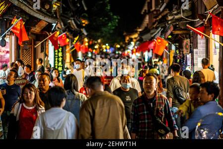 Dali China , 5 October 2020 : Crowd of Chinese people in Dali old town at night with man wearing face mask during 2020 golden week in Dali Yunnan Chin Stock Photo