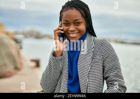 Young african american businesswoman smiling happy talking on the smartphone at the port. Stock Photo