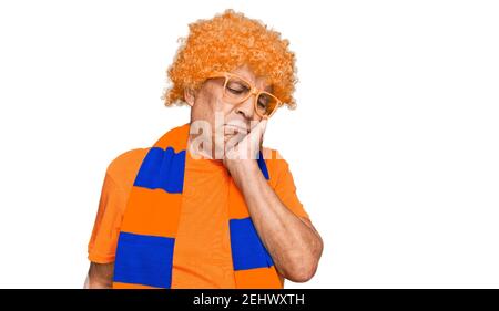 Senior hispanic man football hooligan cheering game thinking looking tired and bored with depression problems with crossed arms. Stock Photo