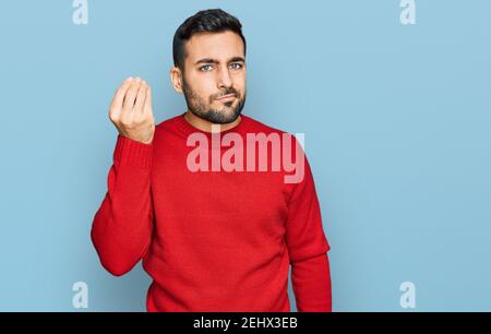Young hispanic man wearing casual clothes doing italian gesture with hand and fingers confident expression Stock Photo