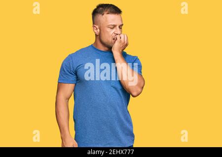 Handsome muscle man wearing casual clothes looking stressed and nervous with hands on mouth biting nails. anxiety problem. Stock Photo