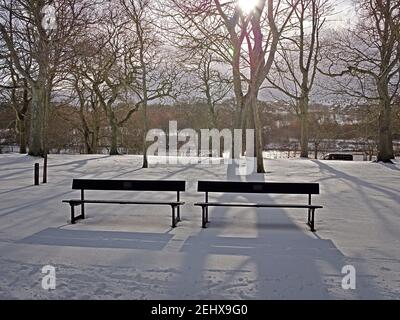 Two empty park benches in the snow in Duthie Park Aberdeen Stock Photo