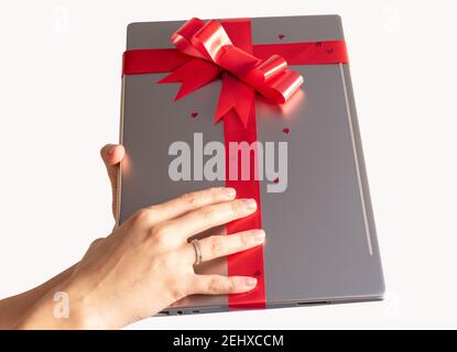 laptop wrapped with red gift bow with background ornaments Stock Photo