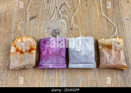 close up of used and new tea bags lined up on wooden table Stock Photo