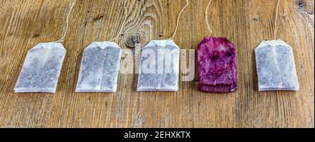 close up of new and used tea bags lined up on wooden table Stock Photo