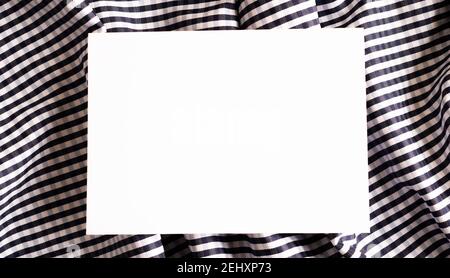 white sheet of paper against the background of crumpled fabric Stock Photo