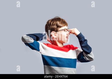 Confused schoolboy in glasses scratching his head Stock Photo