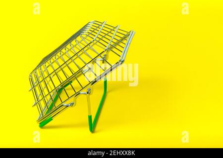 Metal shopping basket on yellow background Stock Photo