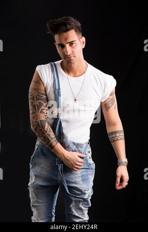 Young man wearing denim overalls and white t-shirt Stock Photo