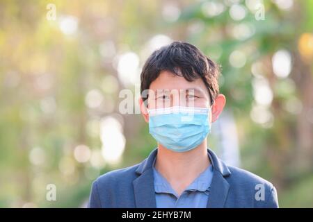 Man wearing a cloth mask in public area protect himself from risk of disease, people prevent infection from coronavirus Covid-19 or Air pollution Stock Photo