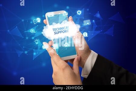Female hand holding smartphone with TECHNICAL SUPPORT inscription, cloud technology concept Stock Photo