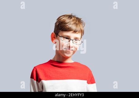 Confused schoolboy in glasses scratching his head Stock Photo