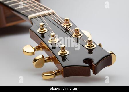 Close up of an acoustic guitar head with tuning keys on a white background Stock Photo