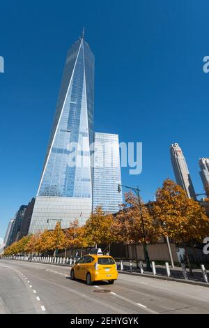 One World Trade center and the other Lower Manhattan skyscraper stands behind the autumn leaf color trees at New York City NY USA. Stock Photo