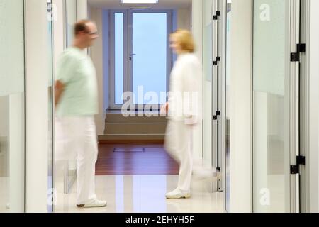 Two Blurry Doctors in a Clinic Passing Each Other Stock Photo