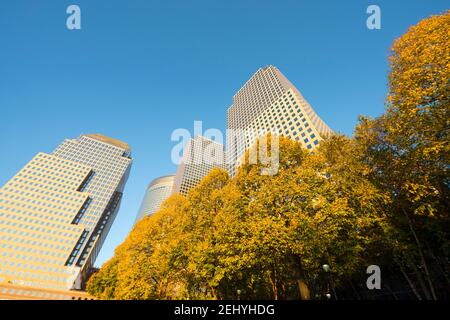 Lower Manhattan skyscraper stands behind the autumn leaf color trees along the Hudson River at New York City NY USA. Stock Photo