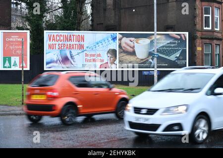 Greenock, Scotland, UK. 20 February 2021. Pictured: Image of Scottish First Minister, Nicola Sturgeon with graphic of a COVID19 vaccine and a syringe with the slogan, “VACCINATION NOT SEPARATION. DO YOUR JOB, FIRST MINISTER.” on a billboard in the middle of Greenock at a busy crossroads of Brougham St & Campbell St. This is in reference to the silent majority of people in Scotland who oppose the SNP trying for a second independence referendum in the middle of a pandemic which has killed over 106,000 people in the UK of which 6,816 deaths in Scotland alone. Credit: Colin Fisher/Alamy Live News. Stock Photo