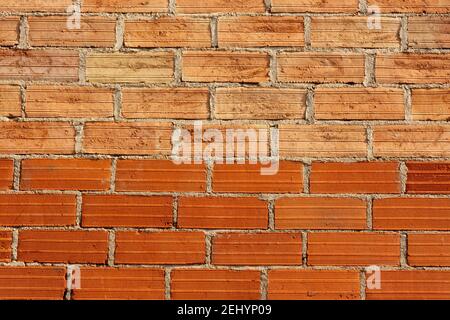 Red brick wall with textured surface creating a rustic and sturdy appearance for construction design Stock Photo