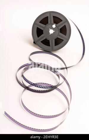 Film reel with unspooled film strips placed on a neutral background in ...
