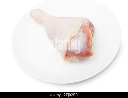 One RAW turkey leg on a white plate isolated on a white bacground. With clipping path Stock Photo