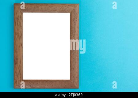 wooden picture frame with white interior on light blue wall Stock Photo
