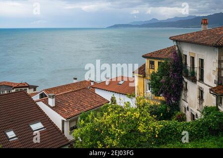 Colorful houses against seascape backdrop. Picturesque coastal landscape. Small fishing village of Llastres in Asturias, Costa Verde, Spain. Stock Photo