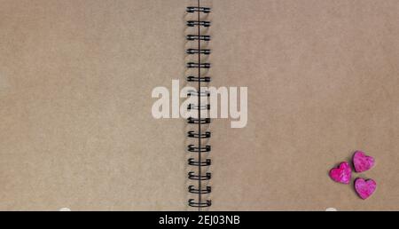 cardboard brown paper ring notebook with wooden red hearts Stock Photo