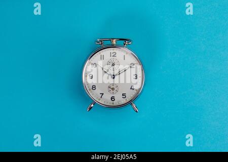 vintage chrome alarm clock on light blue background Stock Photo