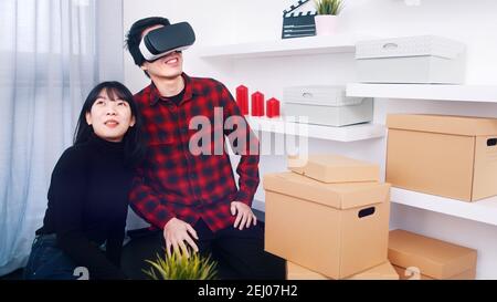 Young couple moving in. Young man using VR glasses. High quality photo Stock Photo